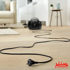 این تصویر یک جاروبرقی مشکی رنگ را در یک اتاق نشان می‌دهد که توسط برند «MahCenter» ارائه شده است.
